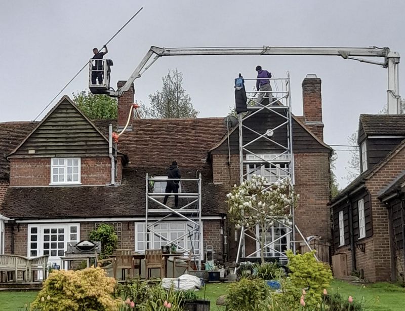 The Moss Cleaners using cherry picker and scaffolding to clean roof safely and professionally in Redlynch, Wiltshire